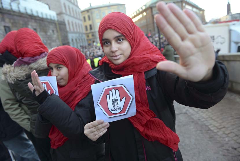 epa04544908 Two young girls carrying leaflets reading 'don't touch my mosque' participate in a demonstration at the house of parliament in Stockholm, Sweden, 02 January 2015. Police have tightened security around some of Sweden's main mosques, after the mosque suffered a firebomb attack a day earlier, one of three arson attacks targeting the muslim community in Sweden since Christmas Day.  EPA/FREDRIK SANDBERG SWEDEN OUT