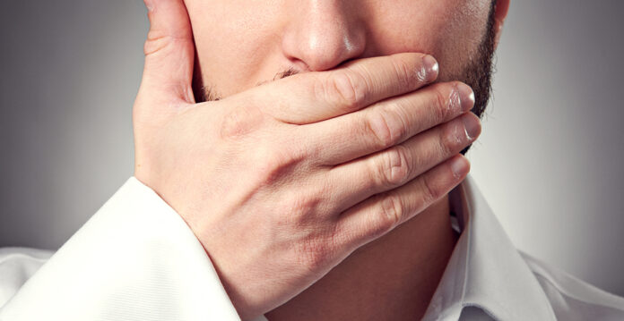 man holding hand over his mouth