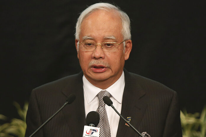 Malaysia's Prime Minister Najib Razak makes an announcement on the latest development on the missing Malaysia Airlines MH370 plane at Putra World Trade Center in Kuala Lumpur