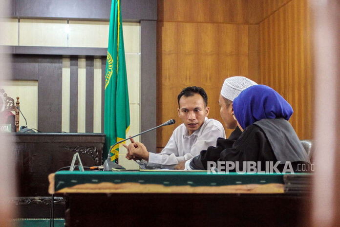 Terdakwa penyebar ujaran kebencian Jasriadi (Saracen Grup) berdialog dengan penasihat hukum usai mendengarkan pembacaan vonis di Pengadilan Negeri (PN) Pekanbaru, Jumat (6/4). Jasriadi dinyatakan tidak terbukti melakukan aktivitas penyebaran ujaran kebenc