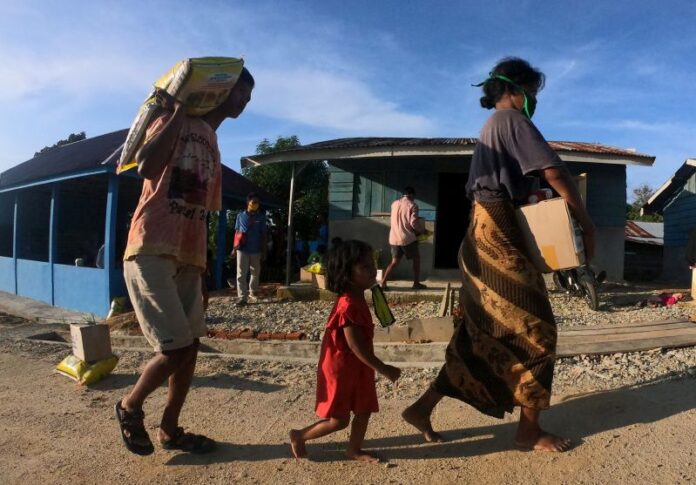 Warga Suku Anak Dalam (SAD) atau Orang Rimba Jambi membawa paket bantuan yang diterimanya di Permukiman SAD, Pelepat, Bungo, Jambi.
