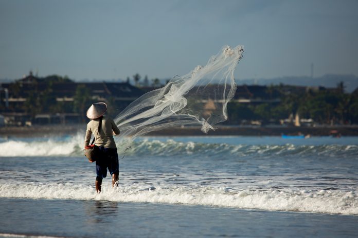 a man is fishing with a net.